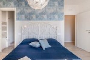 Ein Schlafzimmer mit einem Bett, einer Kopfteil und einer Wand mit einer strukturierten Oberfläche.