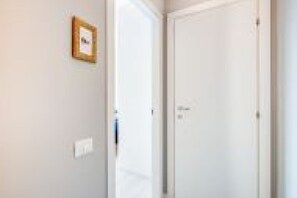 Ein Flur mit einer geschlossenen Tür und einem gerahmten Bild an der Wand.
