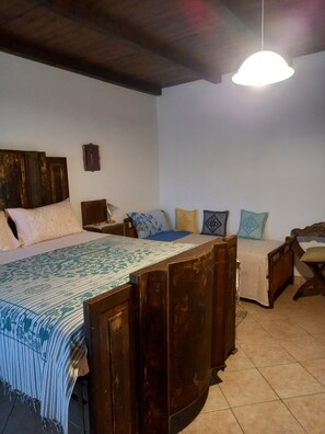 Un dormitorio con una cama de madera, una mesita de noche, una lámpara colgante y un reloj de pared.