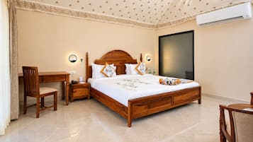 Una habitación de hotel con una cama de madera, un escritorio, una silla y un ventanal grande.