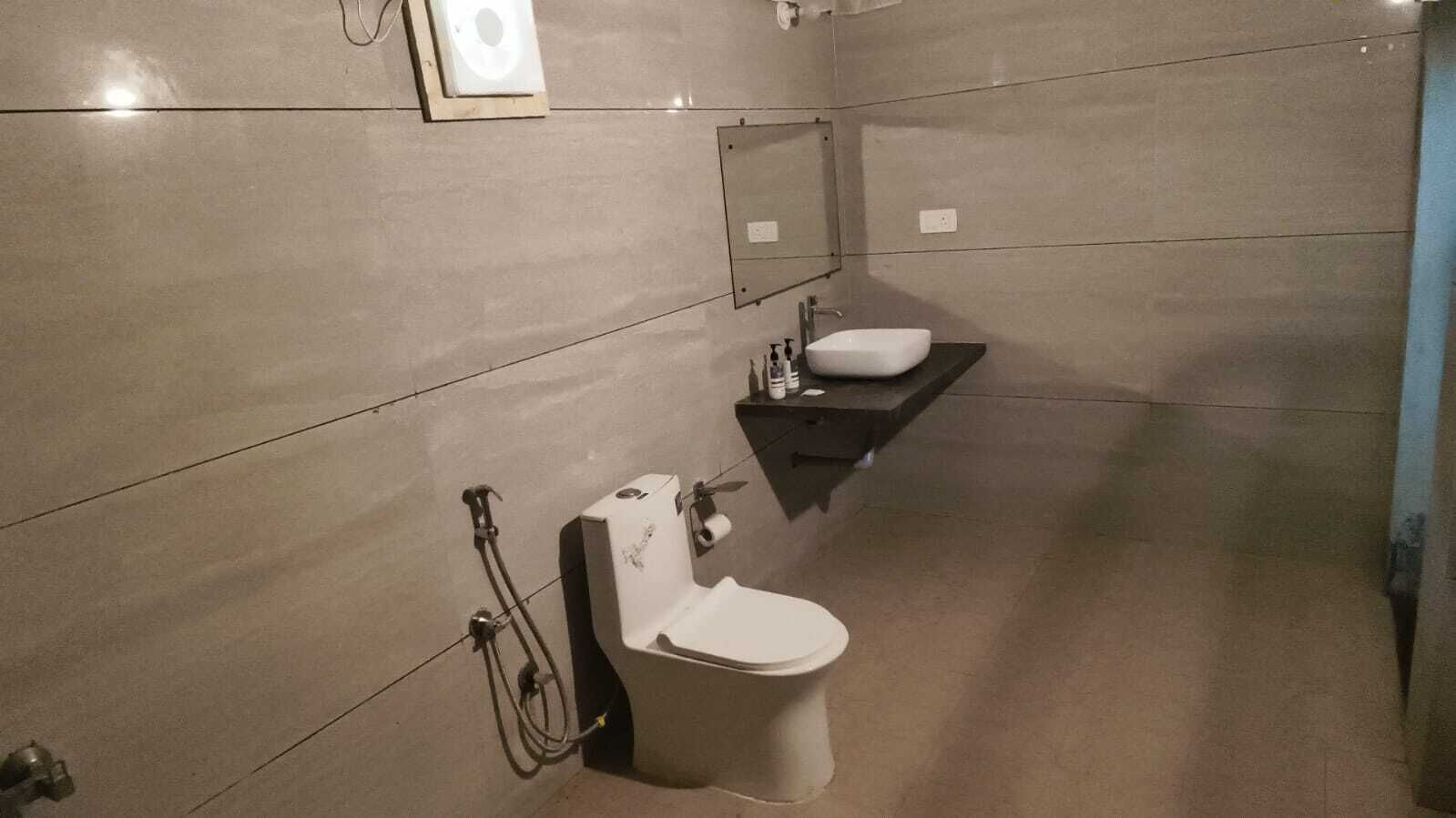 Un baño con inodoro, lavamanos y secador de manos.
