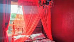 A bedroom with a bed, a chandelier, and a window with curtains. - Cosy 3 bedroom cabin in Fivemiletown. Beside Lake & Town centre. Pet friendly. (Fivemiletown)