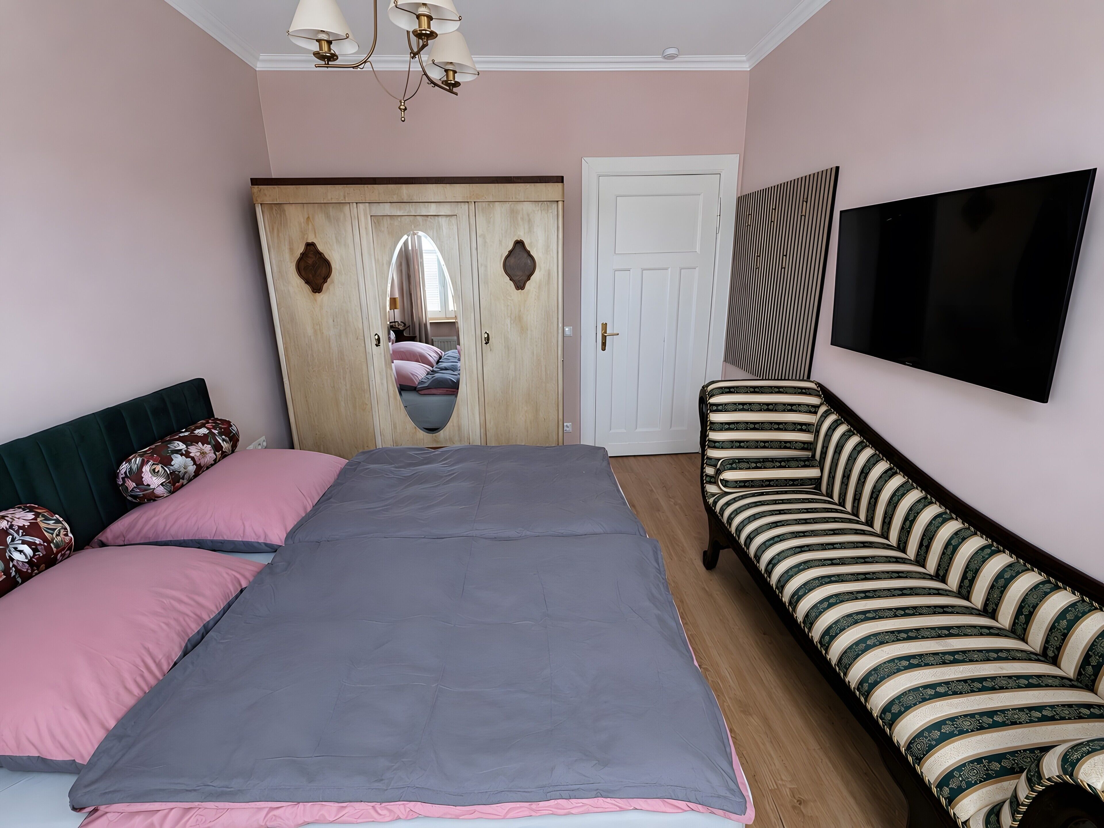 Un dormitorio con cama, sofá, televisión y armario.