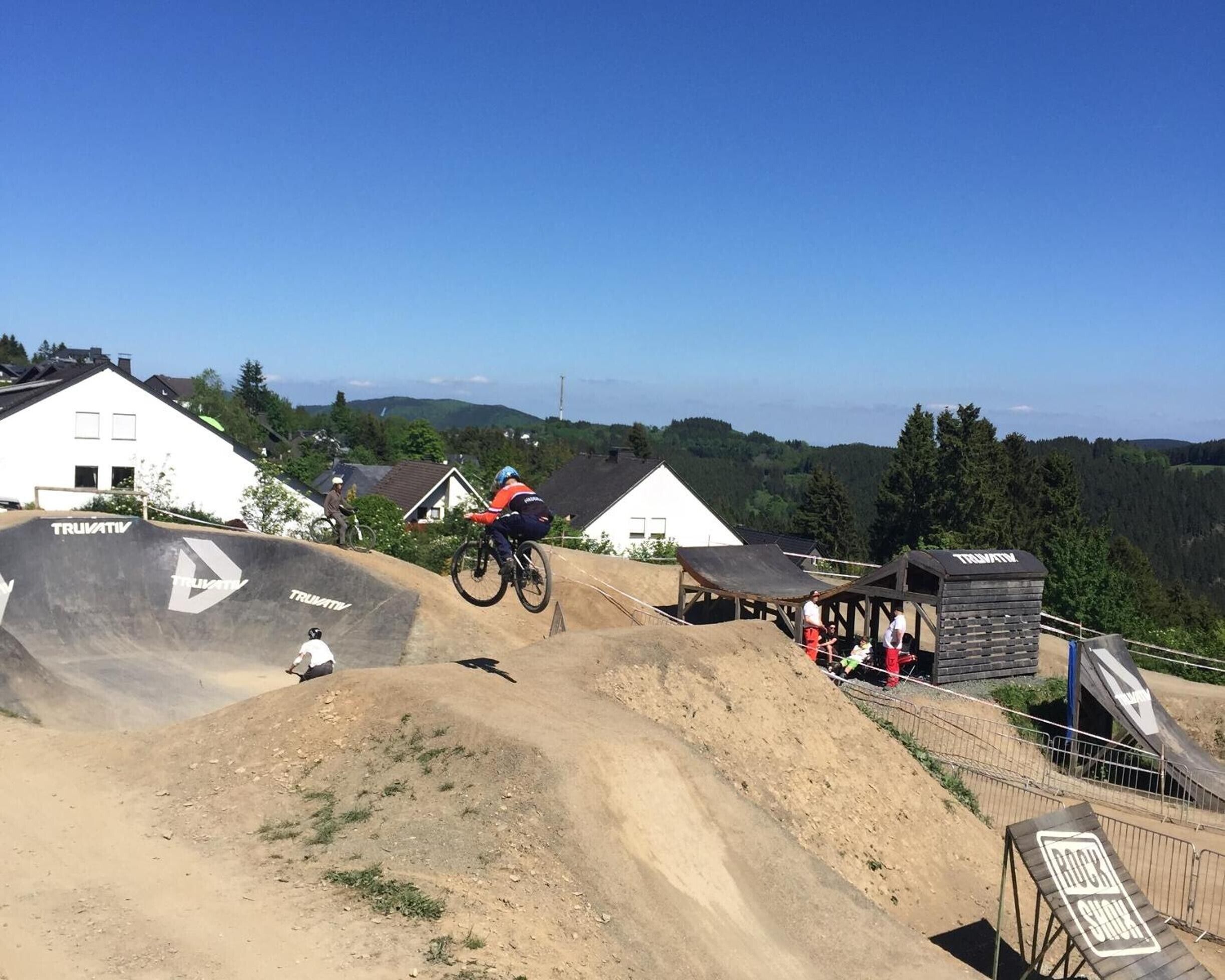 A mountain biking track with a ramp and a spectator area.