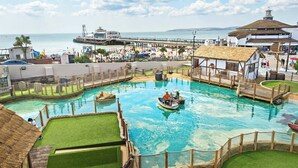Una piscina con una barca, un molo e una zona spiaggia.