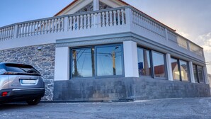 A modern building with a stone facade, large windows, and a balcony. - Casa São Tiago, a Home in Madeira (Ponta do Sol)