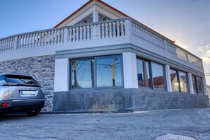Ein modernes Gebäude mit Steinverkleidung, großen Fenstern und einem Balkon.