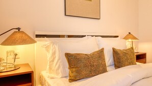 A hotel room with a bed, two nightstands, a lamp, and a framed picture on the wall. - Sunrise House, a Home in Madeira (Ponta do Sol)