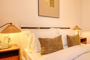 A hotel room with a bed, two nightstands, a lamp, and a framed picture on the wall. - Sunrise House, a Home in Madeira (Ponta do Sol)