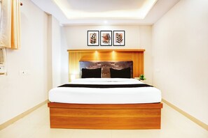 A modern bedroom with a wooden bed frame, a headboard with a tufted design, and three framed artworks above the bed. - Super Collection O Gola Road (Danapur)