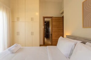 A hotel room with a bed, a wardrobe, and a mirror.