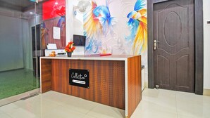 Uma receção com uma placa a indicar serviço da empresa, uma porta com a identificação 301, e uma parede com um mural colorido de peixes.