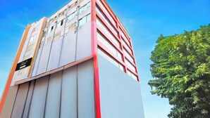 Um edifício com vários andares e design arquitetônico moderno, com um esquema de cores vermelho e branco marcante.
