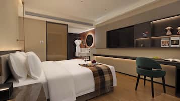 Ein Hotelzimmer mit Bett, Schreibtisch, Stuhl, Fernseher und Minibar.