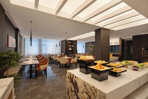 Un comedor moderno con encimera de mármol, distintas disposiciones de asientos y un techo con tragaluces.