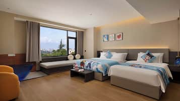 Habitación de hotel con una cama grande, un sofá, una mesita y vistas a la ciudad.