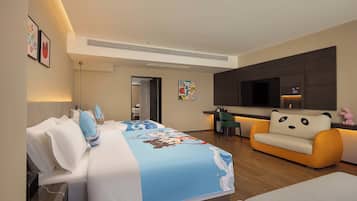 Ein Hotelzimmer mit einem Bett, einem Sofa, einem Schreibtisch und einem Fernseher.