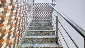 A staircase with a patterned wall on one side and a metal railing on the other. - Collection O Rajeev Nagar Near Atal Path (Patna)