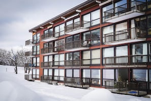 A multi-story building with balconies, large windows, and a snowy landscape. - The Courchevel Nests: LA LOGE, Le Praz (Courchevel)