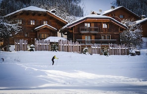 A wooden lodge with a wooden fence in front, set in a snowy landscape. - The Courchevel Nests: LA LOGE, Le Praz (Courchevel)