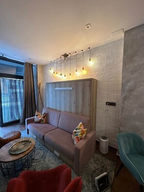 A modern living room with a sofa, a coffee table, and a side table. - Magnificent brand-new home next to Plaza España (Valencia)