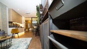 A modern kitchen with a built-in oven, a dining area with a yellow chair, and a staircase leading to an upper level. - Magnificent brand-new home next to Plaza España (Valencia)