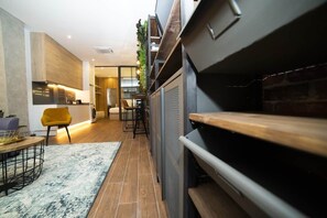 A modern kitchen with a built-in oven, a dining area with a yellow chair, and a staircase leading to an upper level. - Magnificent brand-new home next to Plaza España (Valencia)