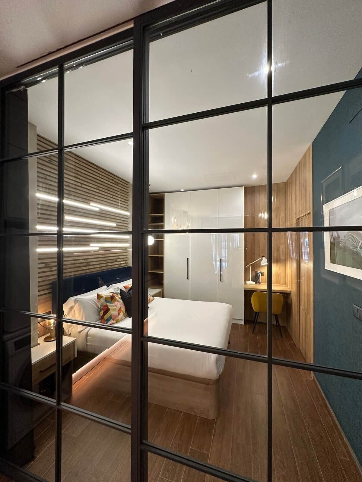 Een moderne hotelkamer met een groot bed, een bureau en een kledingkast.