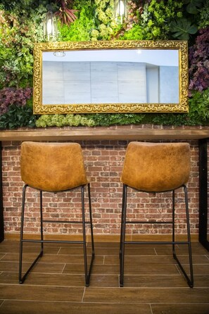 Two bar stools with a brick wall and a mirror with a decorative frame. - Fabulous new home just a stone's throw from Plaza España (Valencia)