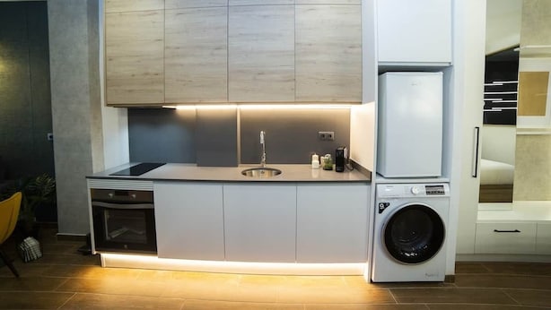 A modern kitchen with built-in appliances, a sink, and a washing machine. - Fabulous new home just a stone's throw from Plaza España (Valencia)