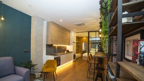 A modern kitchen with a central island, a dining area with bar stools, and a seating area with a sofa and chairs. - Fabulous new home just a stone's throw from Plaza España (Valencia)