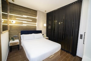 Ein modernes Schlafzimmer mit einem Bett, Nachttischen, einer Wandleuchte und einer Schiebetür.