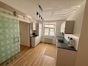 A modern kitchen with a window, a radiator, and a countertop.