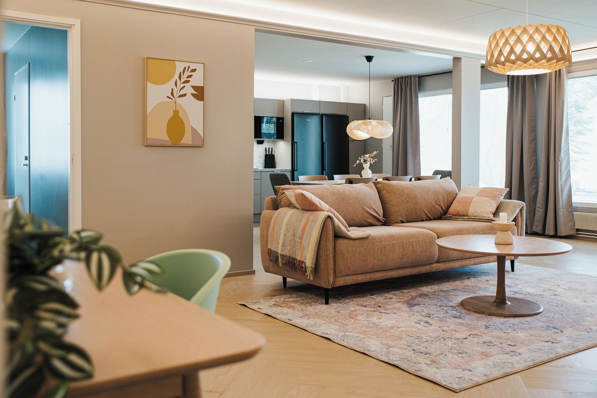 Una sala de estar moderna con un sofá, una mesa de comedor y una cocina al fondo.