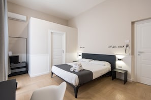 Una camera da letto moderna con un letto, comodini, una sedia e una scrivania.