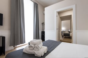 Una camera d'albergo con un letto, una televisione, una scrivania e un armadio.