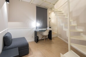 A modern room with a desk, a chair, a sofa, and a staircase. - Five Boutique Rooms - Camera 1 (Naples)