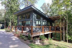 A cabin with a deck, surrounded by trees. - Gorgeous new 1 bedroom with king bed, outdoor firepit, hot tub, lots of light! (Sevierville)