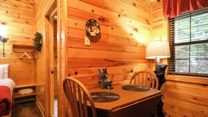 Un interior de madera con una mesa de comedor, sillas, una lámpara y una estatua de oso.