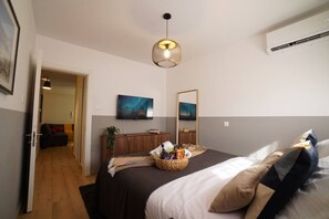A hotel room with a bed, a TV, a mirror, and a wall-mounted air conditioner. - 4.97 Super Host`s New Boutique & Prime Location (Limassol)