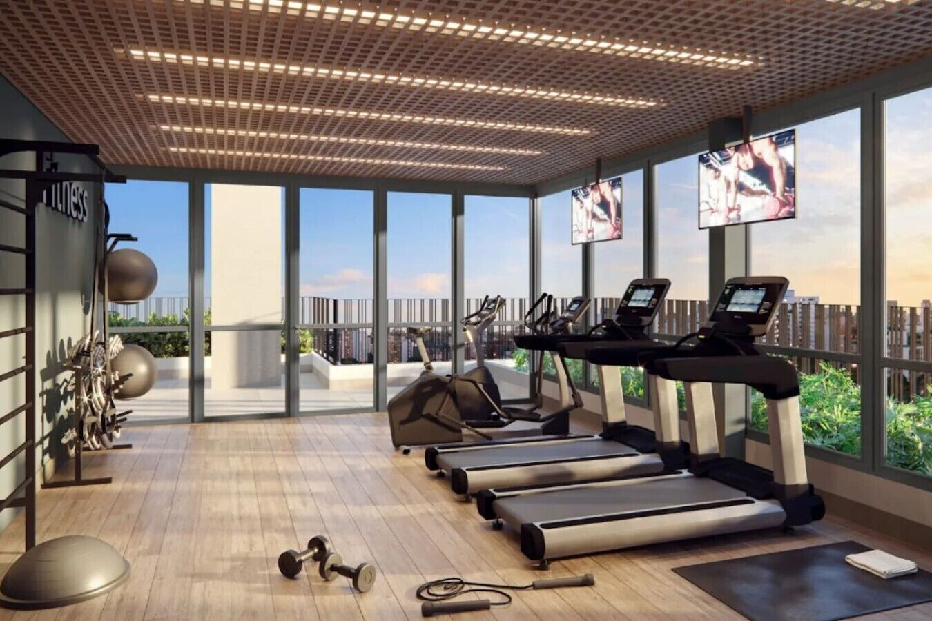 A modern gym with treadmills, elliptical machines, and free weights.