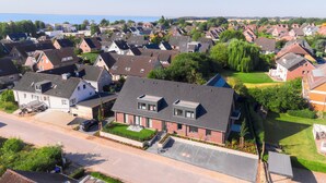 A residential area with houses, a road, and a body of water in the distance. - Wind Force 7 - Sea State. Sauna. Patio. Dog-Friendly (Grömitz)