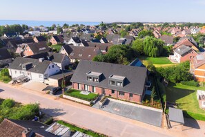 A residential area with houses, a road, and a body of water in the distance. - Wind Force 7 - Sea State. Sauna. Patio. Dog-Friendly (Grömitz)