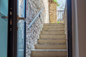 Un escalier avec un mur à texture sur un côté et une rampe en métal.