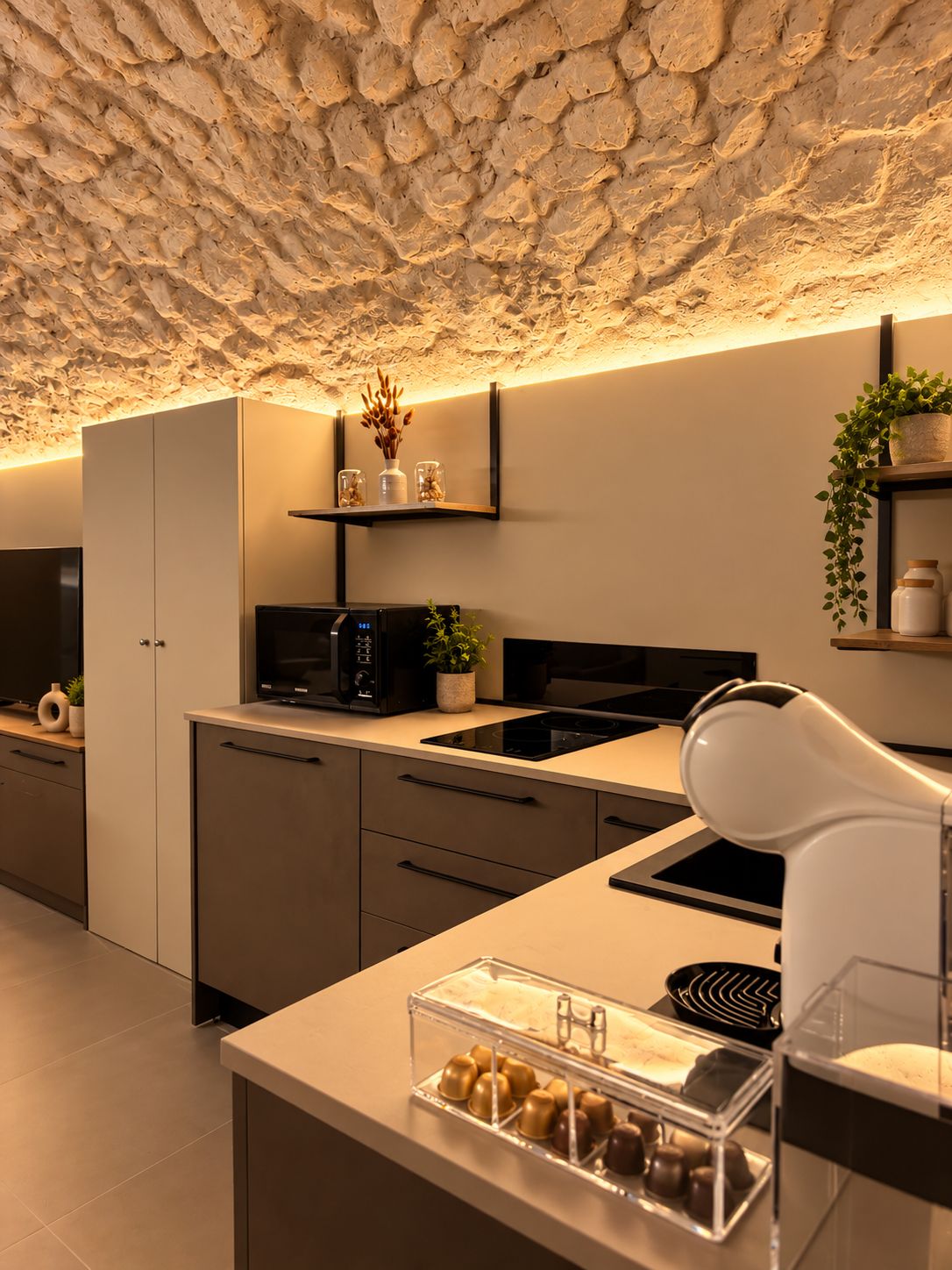 Una cocina moderna con techo de piedra, electrodomésticos integrados y una encimera con una exhibición de alimentos.
