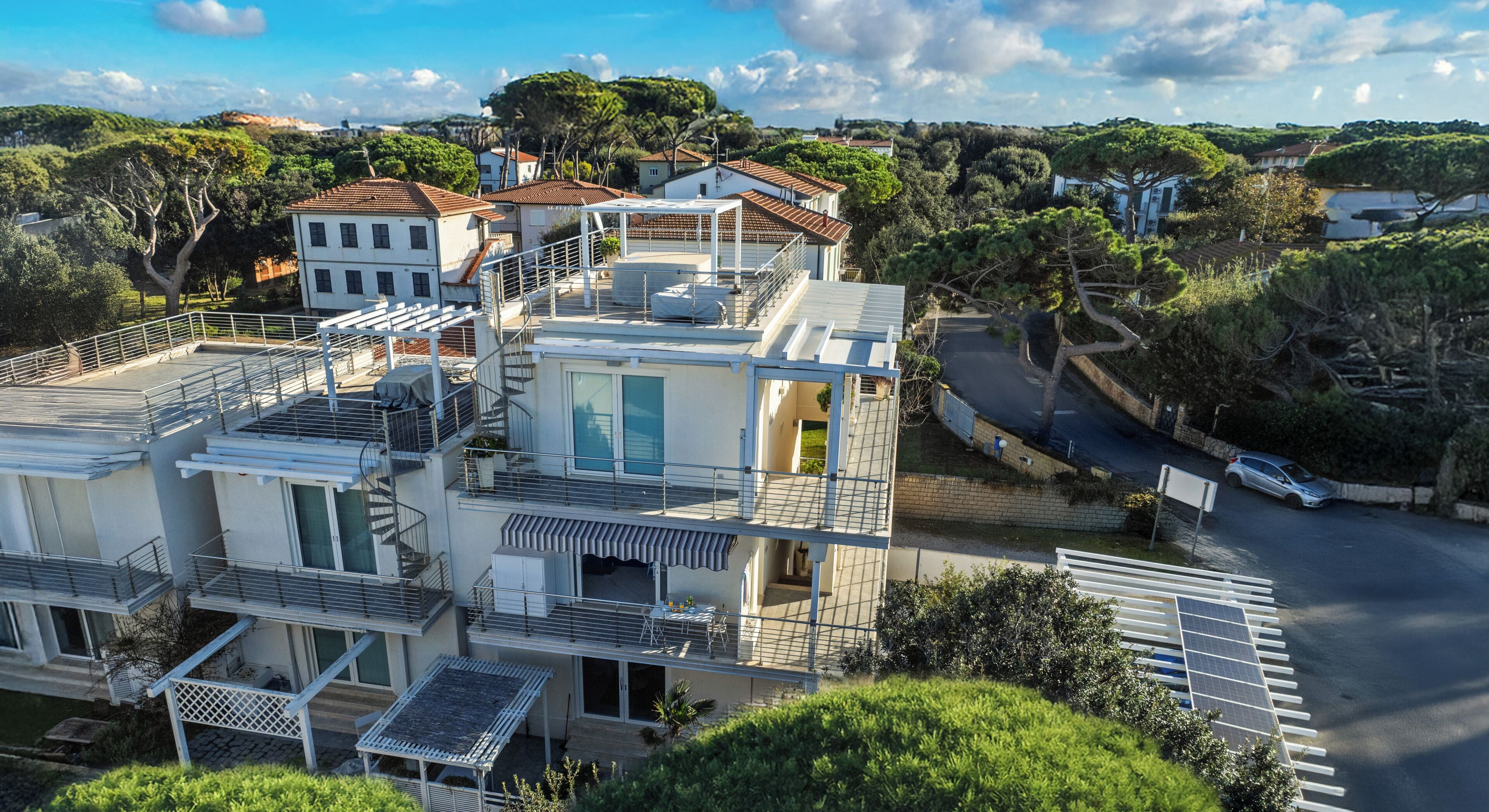 Un immeuble résidentiel à plusieurs étages doté d’une terrasse sur le toit, d’une piscine et d’un ensemble de panneaux solaires.