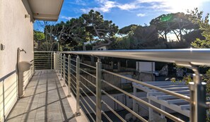 A balcony with a metal railing, a stone sink, and a view of trees and a building in the background. - BLUE OCEAN-VIEW APARTMENT, terrace, air conditioning, internet, and parking space (San Vincenzo)