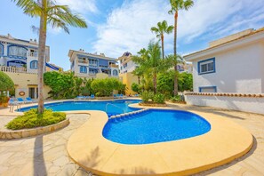 A resort with a swimming pool, palm trees, and a clear blue sky. - Hanami Apartment - Plusholidays (Calpe / Calp)