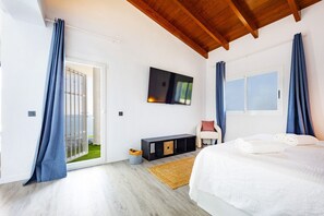 A bedroom with a bed, a TV, a sliding door, and a window. - Villa Infinitysea - PlusHolidays (Altea)