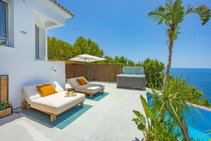 A modern outdoor living area with a pool, lounge chairs, and a hot tub. - Villa Infinitysea - PlusHolidays (Altea)
